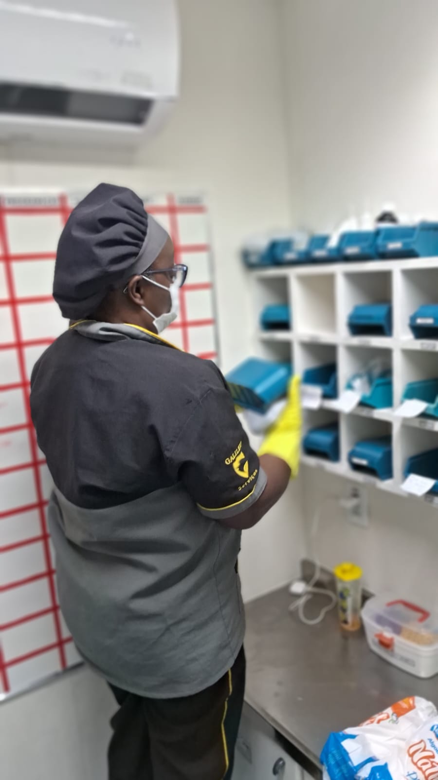 Colaboradora Galileu limpando parede decorada com rodo em quarto infantil de unidade de saúde
